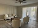 Cozy living room featuring a sofa, armchairs, ceiling fan, and sliding glass doors at 544 Orange Dr # 10, Altamonte Springs, FL 32701