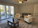 Bright living room with patio access, armchairs, and modern décor at 544 Orange Dr # 10, Altamonte Springs, FL 32701