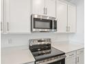 The kitchen features stainless steel appliances, sleek countertops, and white cabinets for a modern look at 2107 Riley Ave, Eagle Lake, FL 33839
