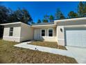 Tan house with white trim and a two-car garage at 6809 149Th Lane Rd, Ocala, FL 34473