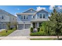 Charming two-story home with an attached two-car garage, landscaped front yard, and covered porch at 11843 Imaginary Way, Orlando, FL 32832