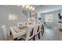 Well-lit dining area leading to a living room, featuring a stylish table, chairs, and modern decor at 2505 Dharma Cir, Kissimmee, FL 34746