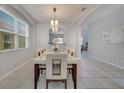 Elegant dining room with a modern light fixture, a large table, and plenty of natural light at 2505 Dharma Cir, Kissimmee, FL 34746