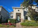 Two-story house with light beige siding, green door, and landscaped front yard at 2927 Windmill Dr, Kissimmee, FL 34741