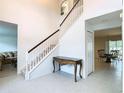 Bright entryway with staircase, tile floors, and console table at 4610 Salamander St, St Cloud, FL 34772