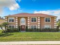 Front view of a two-story house with a brown facade, red roof, and well-maintained lawn at 4610 Salamander St, Saint Cloud, FL 34772