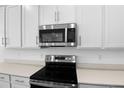 Close up of a modern kitchen featuring stainless steel microwave and electric stove at 2007 Stetson Ave, Eagle Lake, FL 33839
