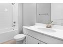 Clean bathroom with a white vanity, toilet, and tiled shower-tub combination at 1651 Sugarbelle Cir, Mascotte, FL 34753