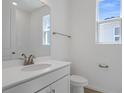 A bathroom with a white vanity, neutral walls, a window with bright natural light, and modern fixtures at 1655 Sugarbelle Cir, Mascotte, FL 34753