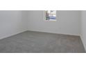 Bright bedroom with neutral carpet, white walls, a window providing natural light, and electrical outlets at 1655 Sugarbelle Cir, Mascotte, FL 34753