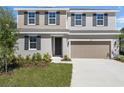 Inviting two-story home featuring a two-car garage, neutral siding, manicured lawn and a welcoming front entrance at 1667 Sugarbelle Cir, Mascotte, FL 34753