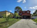 Charming two-story home with a spacious driveway, attached garage and luscious front yard at 438 Spike Ct, Kissimmee, FL 34759