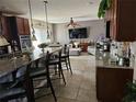 Modern kitchen with granite countertops, breakfast bar, stainless steel appliances, and an open living space at 438 Spike Ct, Kissimmee, FL 34759