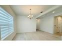 Bright dining room featuring a modern chandelier and horizontal blinds at 13193 Tollcross Way, Winter Garden, FL 34787