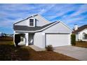 Front view of a light gray house with a white garage door and a neatly trimmed lawn at 523 Royal Ridge Dr, Davenport, FL 33837