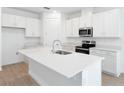 Modern kitchen with white cabinetry, stainless steel appliances, and a spacious island at 1753 Carnelian St, Deland, FL 32720
