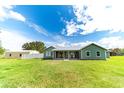 Inviting backyard with well-maintained lawn, a cozy porch with rocking chairs, and a charming home exterior at 4121 Albritton Rd, St Cloud, FL 34772