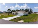 Well-maintained single-story home with a two-car garage, landscaped front yard, and a long concrete driveway at 1415 Orlando Way, Kissimmee, FL 34759