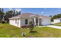 Attractive single-story home featuring a two-car garage, manicured lawn, and colorful flowerbeds in a bright setting at 1415 Orlando Way, Kissimmee, FL 34759