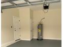 Garage interior with door to house, storage, and water heater at 1415 Orlando Way, Kissimmee, FL 34759