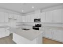 Bright kitchen with white cabinets, stone countertops, an island, and stainless steel appliances at 5410 Catmint Dr, Lake Hamilton, FL 33851