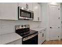 Close up of the kitchen with stainless steel oven, microwave, white cabinets and subway tile backsplash at 4064 Bannock Ave, Tavares, FL 32778