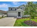 Two story home featuring a two car garage, a front lawn and traditional front door at 1769 Carnelian St, Deland, FL 32720