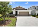 Charming single-Gathering home featuring a two-car garage and a well-manicured front lawn and stone facade at 1771 Carnelian St, Deland, FL 32720
