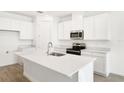 Bright kitchen with modern white cabinets, stainless steel appliances, and a central island at 1771 Carnelian St, Deland, FL 32720
