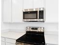 Close-up of the kitchen features stainless steel appliances and white countertops and white cabinetry at 1771 Carnelian St, Deland, FL 32720