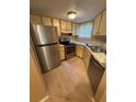 Galley kitchen featuring stainless steel appliances and wood cabinets at 1940 Lake Atriums Cir # 93, Orlando, FL 32839