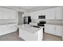 Modern kitchen featuring white cabinets, stainless steel appliances, and a center island at 5418 Catmint Dr, Lake Hamilton, FL 33851