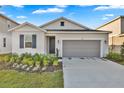 Charming single-story home with a two-car garage, manicured lawn, and inviting front door at 5422 Catmint Dr, Lake Hamilton, FL 33851