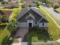 Well maintained single-story home featuring a brick driveway, a two-car garage, and lush landscaping at 3907 Golden Knot Dr, Kissimmee, FL 34746