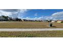 View of expansive parcel of land with sidewalk along the front and various single Gathering homes in the background at 3907 Golden Knot Dr, Kissimmee, FL 34746