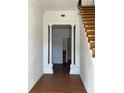 Inviting entryway featuring wood flooring, decorative columns, and stairs leading to the upper level at 701 1St Ne St, Fort Meade, FL 33841