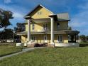 Two-story yellow house with a metal roof and a wraparound porch at 701 1St Ne St, Fort Meade, FL 33841