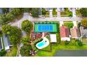 Aerial view of community amenities, including a pool, tennis court, playground, and lake at 2112 Fish Eagle St, Clermont, FL 34714