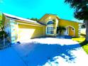 Charming home featuring a two-car garage, well-manicured lawn, and an inviting arched entryway at 2112 Fish Eagle St, Clermont, FL 34714