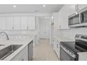 Modern kitchen showcasing white cabinetry, stainless steel appliances, subway tile backsplash, and sleek countertops at 3716 Deer Ridge Dr, Mount Dora, FL 32757