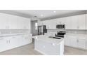 Bright, spacious kitchen with white cabinets, stainless steel appliances and island at 1455 August Gray Dr, Kissimmee, FL 34744