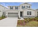 Two-story house with gray siding, stone accents, and a two-car garage at 1461 August Gray Dr, Kissimmee, FL 34744