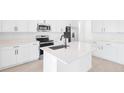 Bright kitchen features white cabinetry, stainless steel appliances, a center island with a sink, and ample counter space at 1485 August Gray Dr, Kissimmee, FL 34744