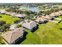 Aerial view of homes in a well-manicured neighborhood overlooking a serene lake and lush landscaping at 3643 Weatherfield Dr, Kissimmee, FL 34746