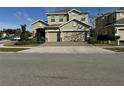 Charming two-story home with a well-manicured lawn and a brick driveway at 1222 Castlevecchio Loop, Orlando, FL 32825