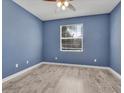 Cozy bedroom with hardwood floors, a ceiling fan, and a window letting in natural light at 1569 Thetford Cir, Orlando, FL 32824