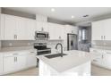 Bright kitchen with white cabinets, stainless steel appliances, quartz counters, and a large island at 3824 Deer Ridge Dr, Mount Dora, FL 32757