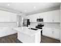 Modern kitchen with white cabinets, island, and stainless steel appliances at 520 Summit River Dr, Apopka, FL 32712