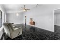 Spacious living room featuring modern marble flooring, a ceiling fan, and a decorative chandelier at 1855 Cavalier Ct, Kissimmee, FL 34744