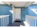 Charming entryway featuring a white front door with a covered porch and blue siding at 8716 Rain Forest Pl # D, Kissimmee, FL 34747